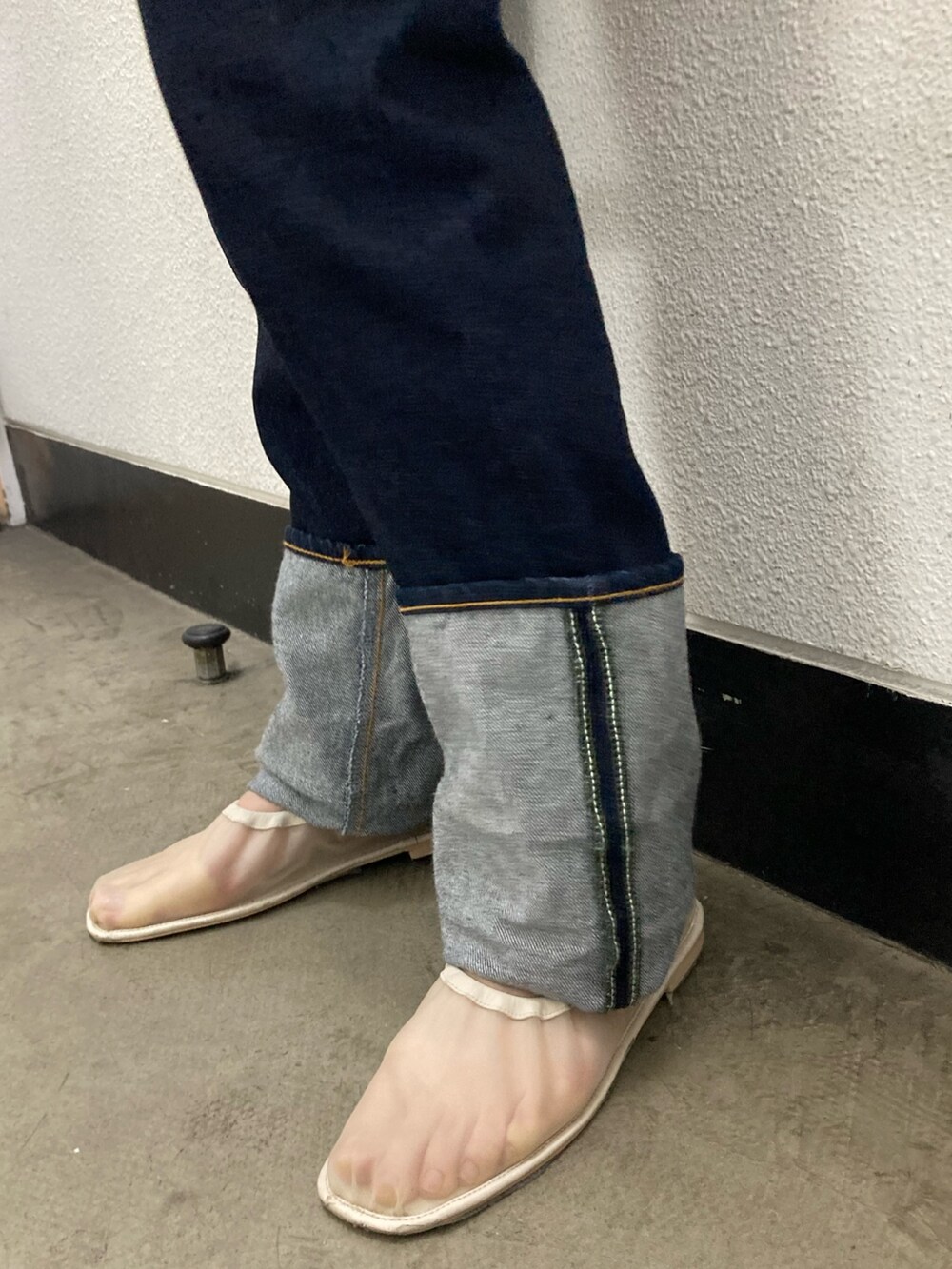 イエロー系のシャツ/ブラウス、ホワイト系のベスト、ブルー系のデニムパンツを着用したレディースの冬コーディネートの4枚目の写真