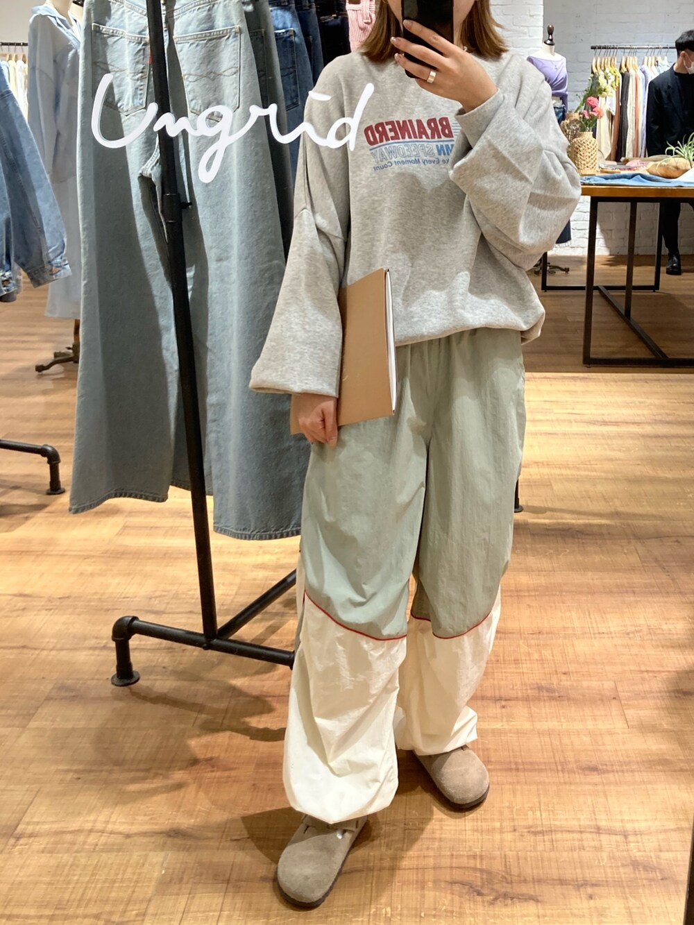 グレー系のスウェット、ホワイト系のその他パンツ、オレンジ系のキャップを着用したレディースの冬コーディネートの2枚目の写真