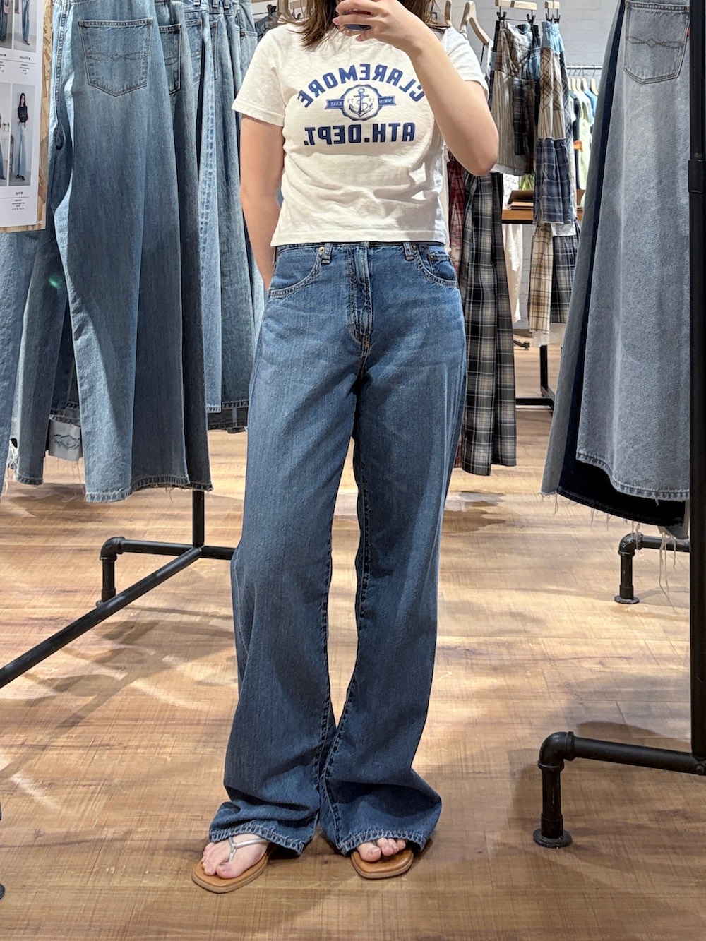 イエロー系のバックパック/リュック、ホワイト系のTシャツ/カットソー、ブルー系のデニムパンツを着用したレディースの春コーディネートの2枚目の写真