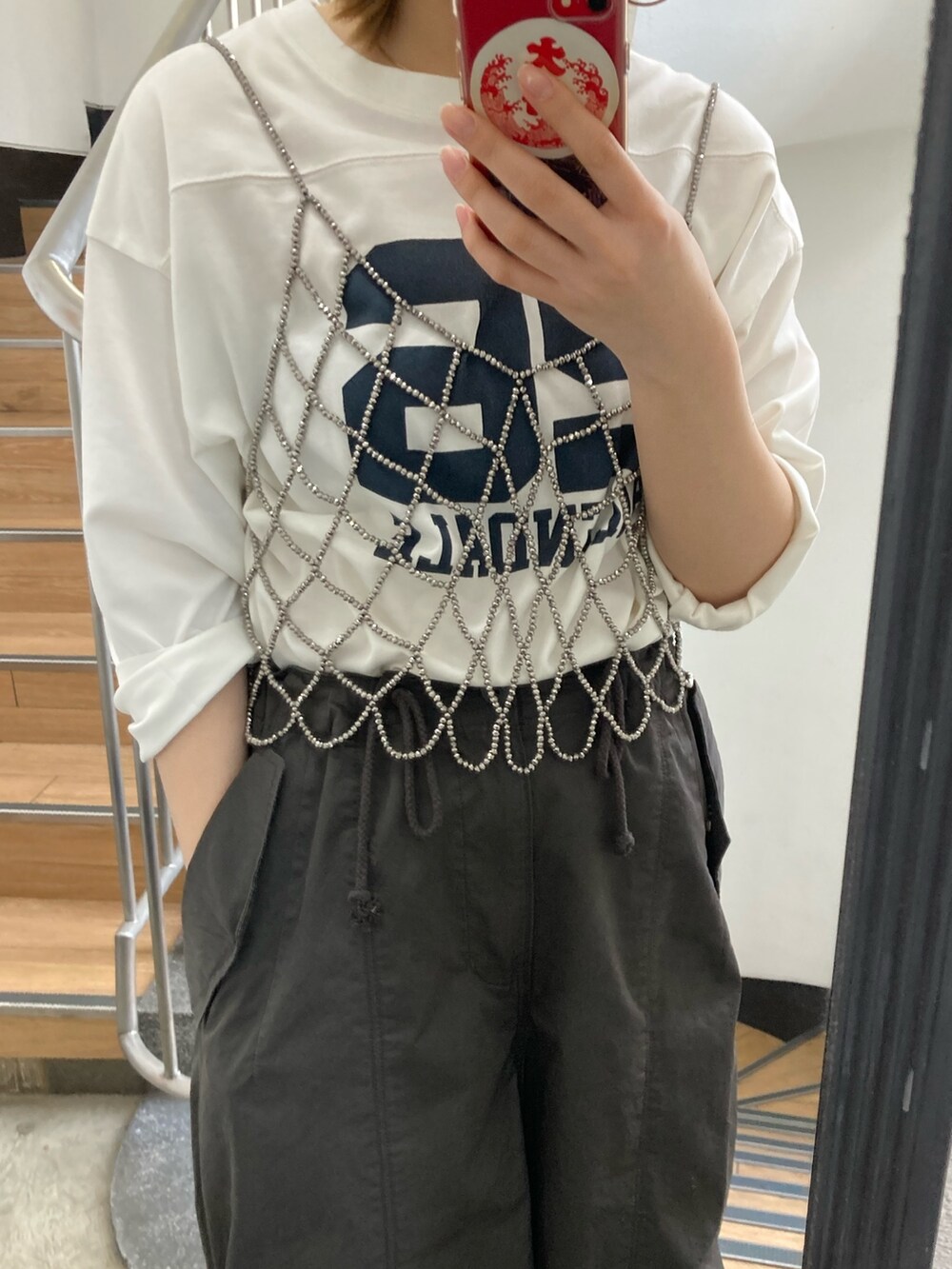 ホワイト系のTシャツ/カットソー、ブラック系のベスト、グレー系のその他パンツを着用したレディースの春コーディネートの4枚目の写真