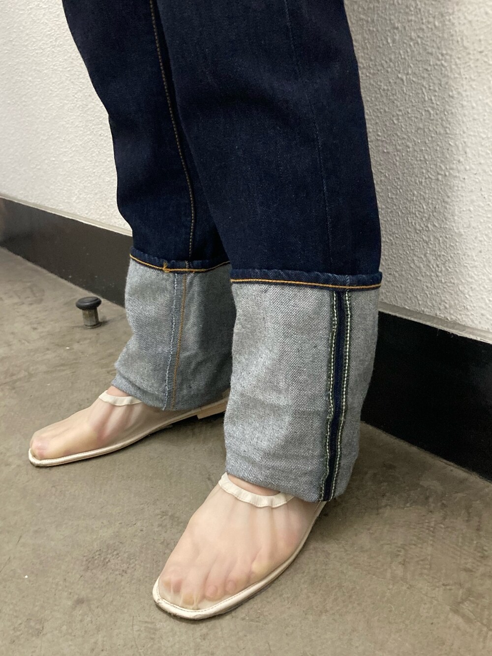 イエロー系のシャツ/ブラウス、ホワイト系のベスト、ブルー系のデニムパンツを着用したレディースの冬コーディネートの3枚目の写真