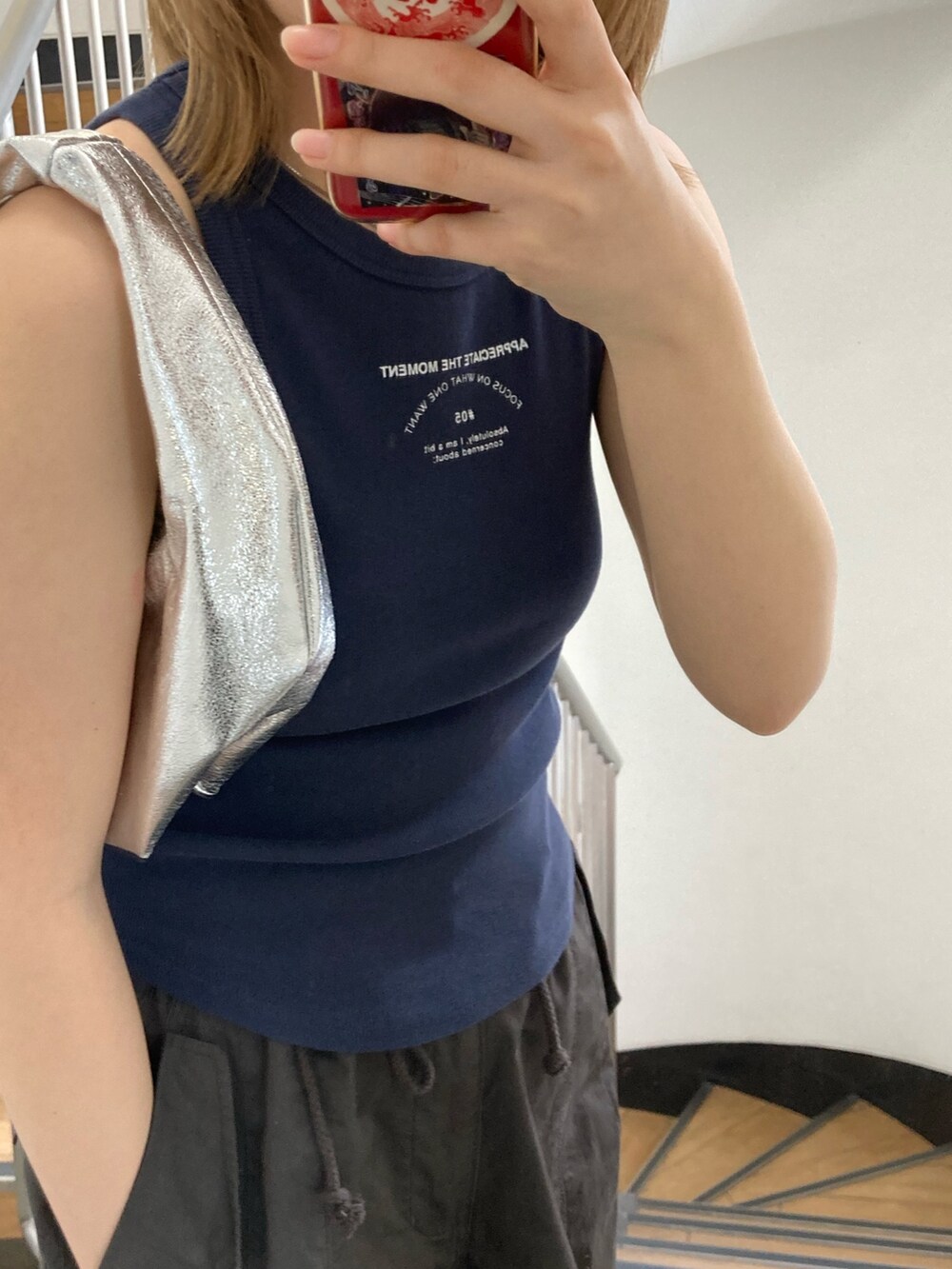 グレー系のその他パンツ、ブルー系のタンクトップ、シルバー系のハンドバッグを着用したレディースの春コーディネートの3枚目の写真