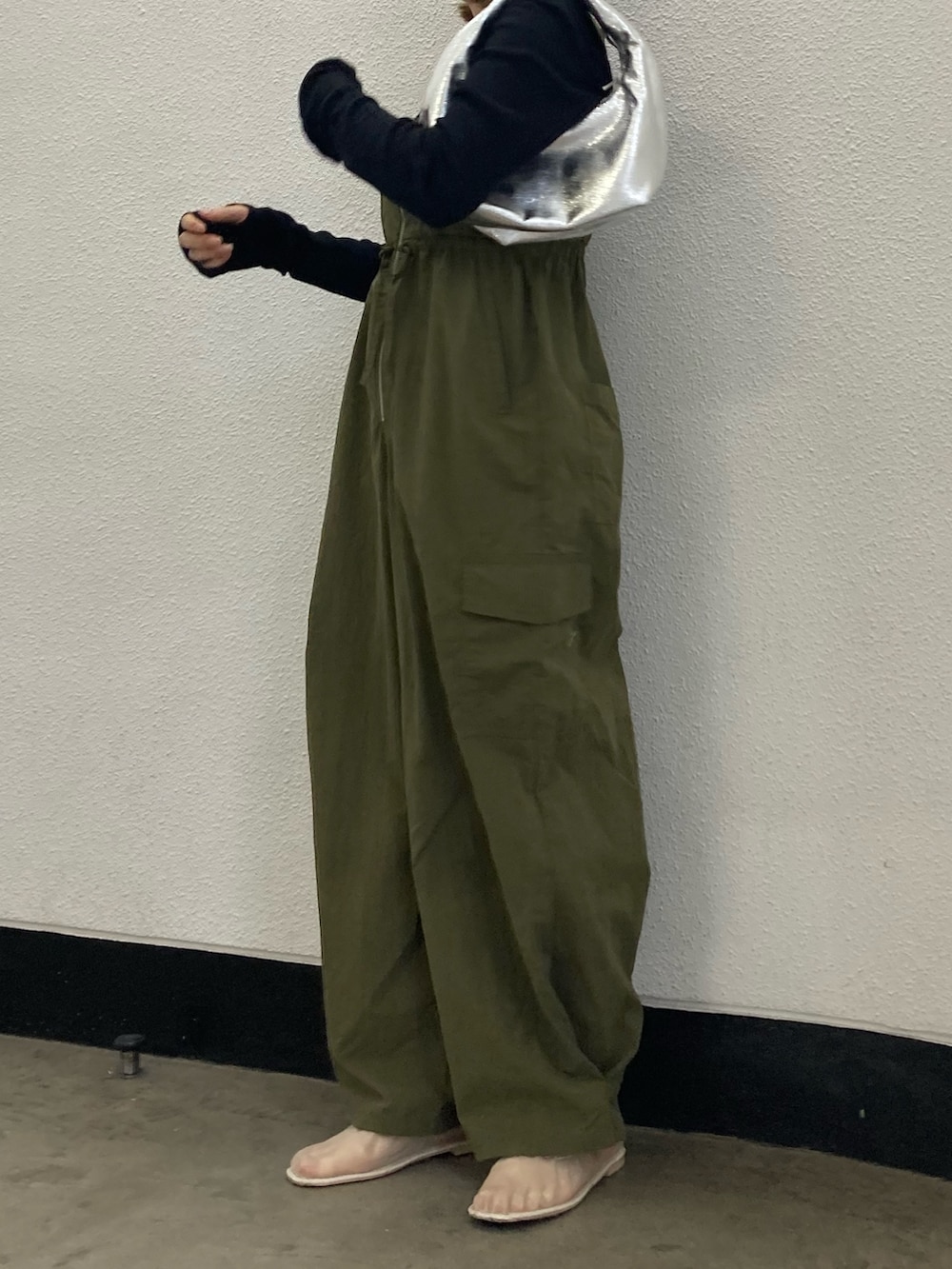 グリーン系のサロペット/オーバーオール、ブラック系のTシャツ/カットソー、シルバー系のハンドバッグを着用したレディースの冬コーディネートの3枚目の写真