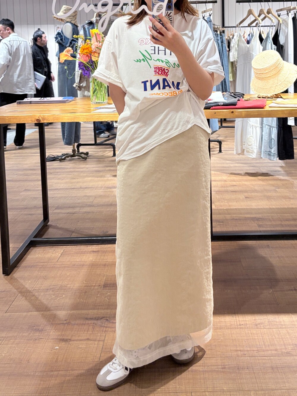 ホワイト系のTシャツ/カットソー、ベージュ系のスカート、ブラック系のメガネを着用したレディースの春コーディネートの2枚目の写真