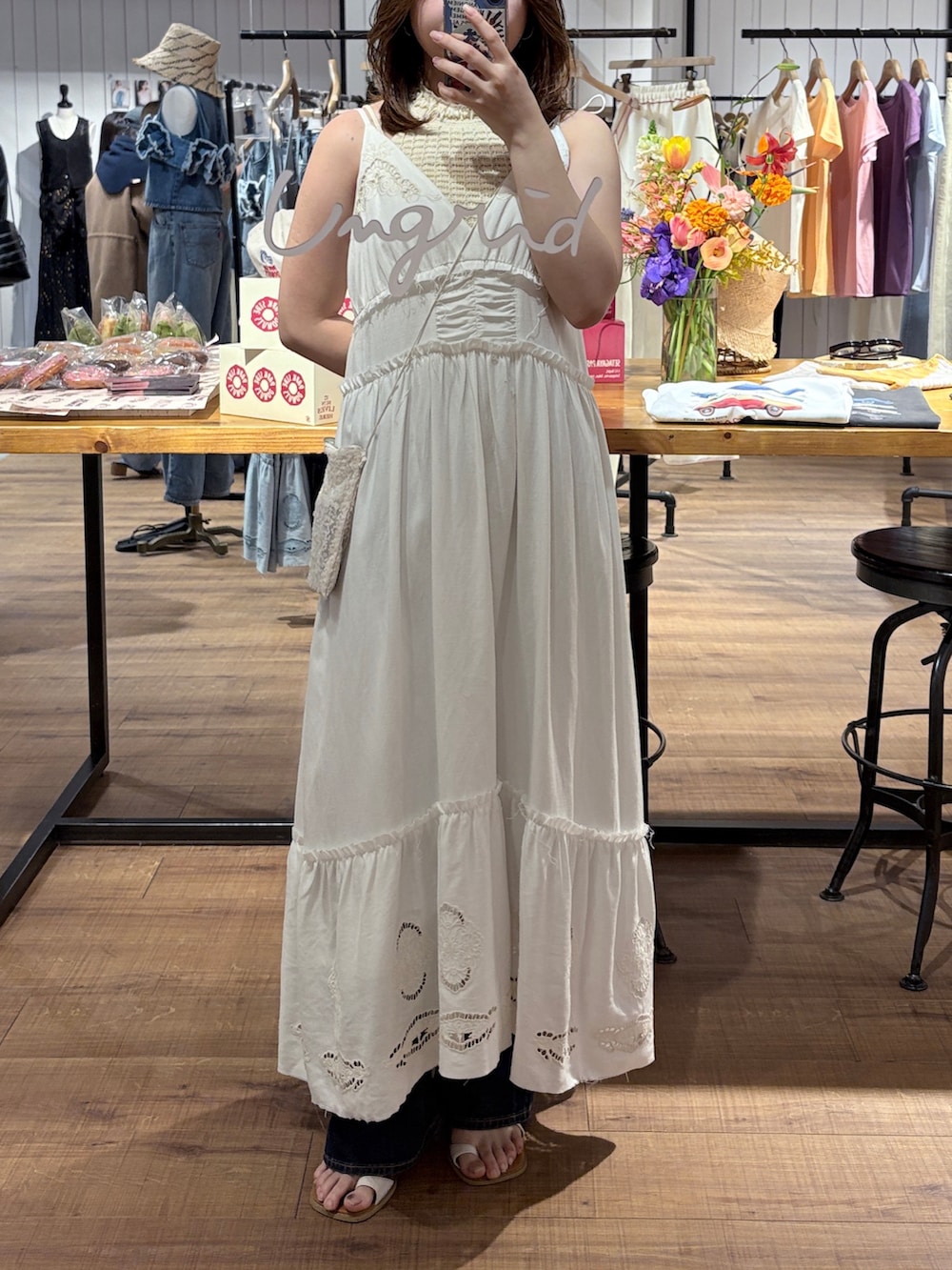 ホワイト系のワンピース、ホワイト系のタンクトップ、ブルー系のデニムパンツを着用したレディースの春コーディネートの2枚目の写真