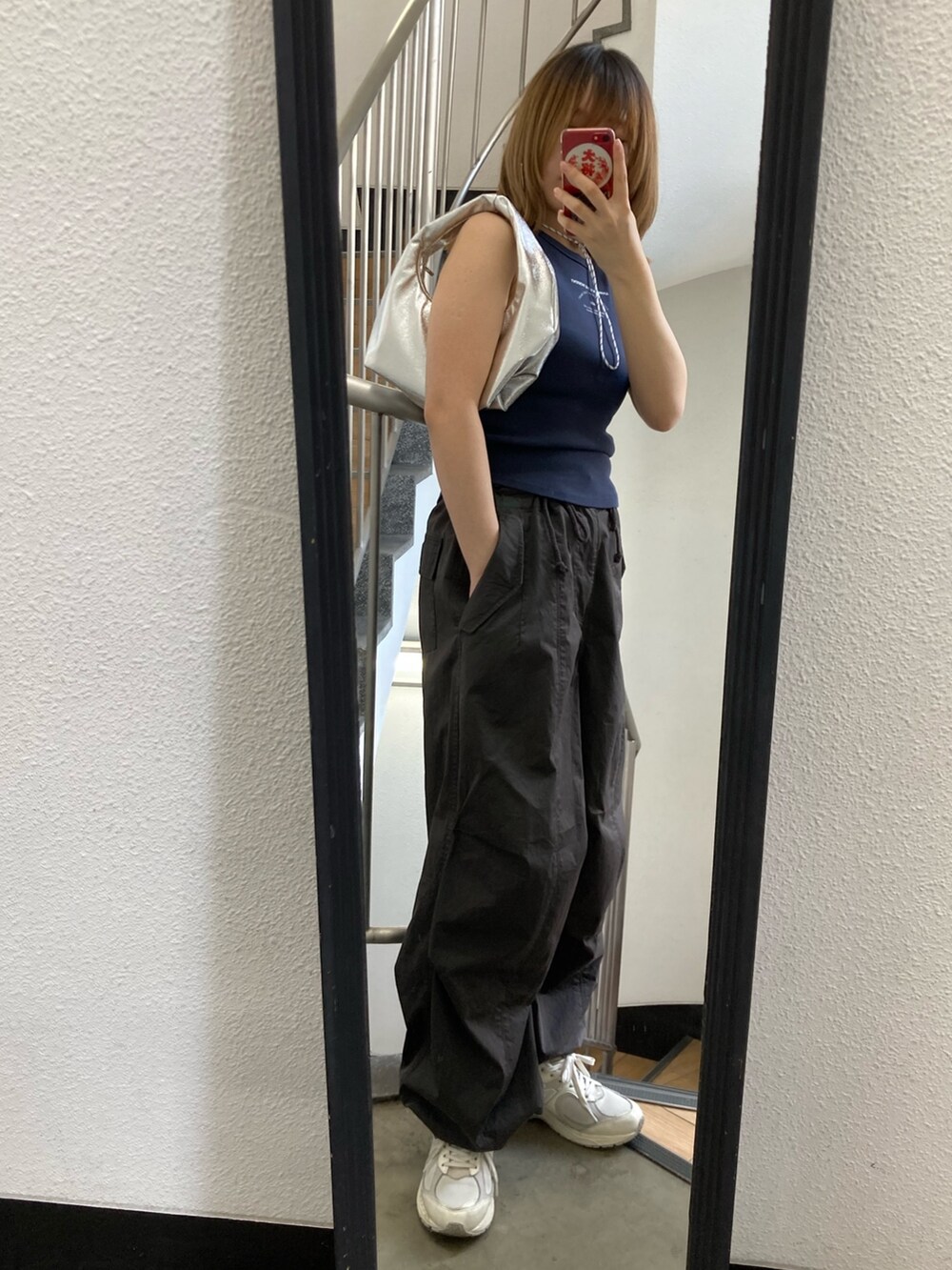 グレー系のその他パンツ、ブルー系のタンクトップ、シルバー系のハンドバッグを着用したレディースの春コーディネートの2枚目の写真