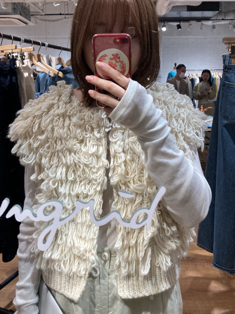 ホワイト系のベスト、ホワイト系のカーゴパンツ、ゴールド系のローファーを着用したレディースの春コーディネートの3枚目の写真