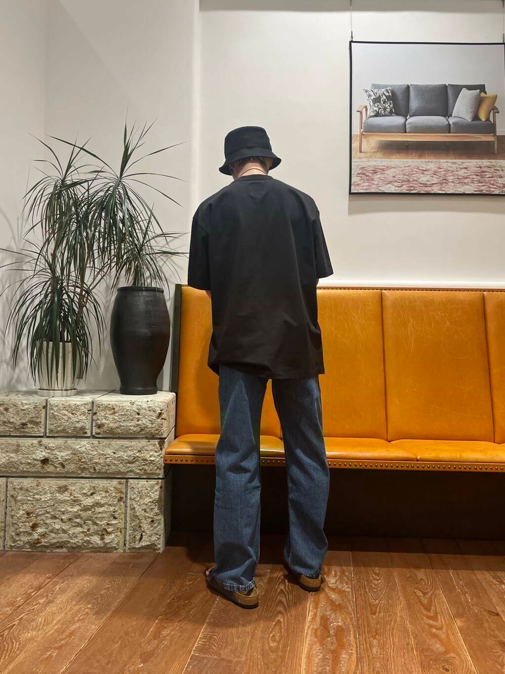 ブルー系のデニムパンツ、グレー系のサンダル、ブラック系のTシャツ/カットソーを着用したメンズの春コーディネートの3枚目の写真