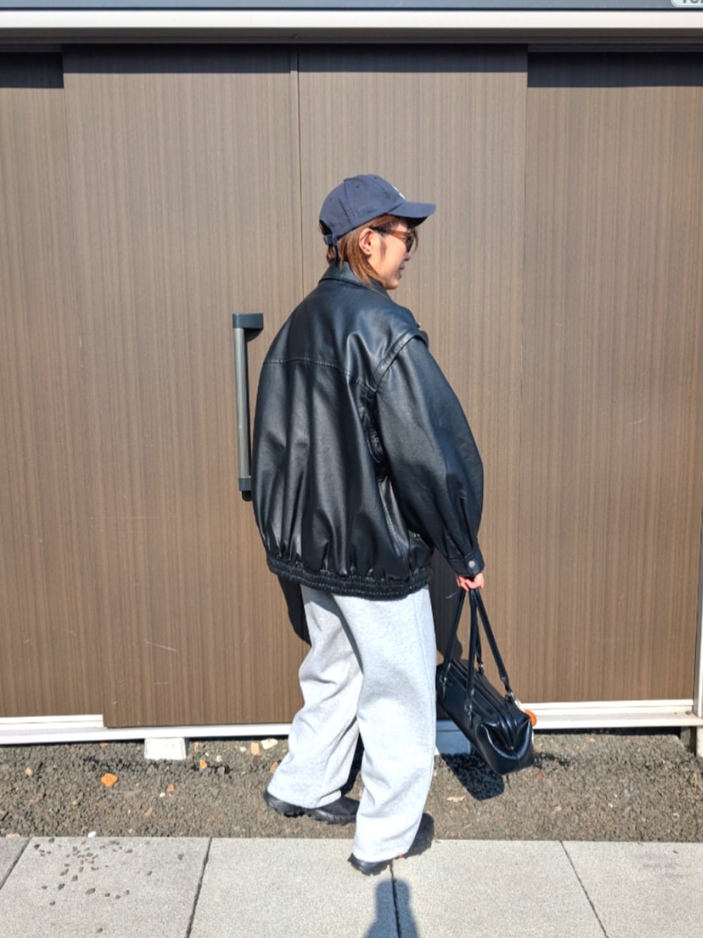 ブラック系のライダースジャケット、グレー系のスウェットパンツ、その他のキャップを着用したレディースの春コーディネートの2枚目の写真