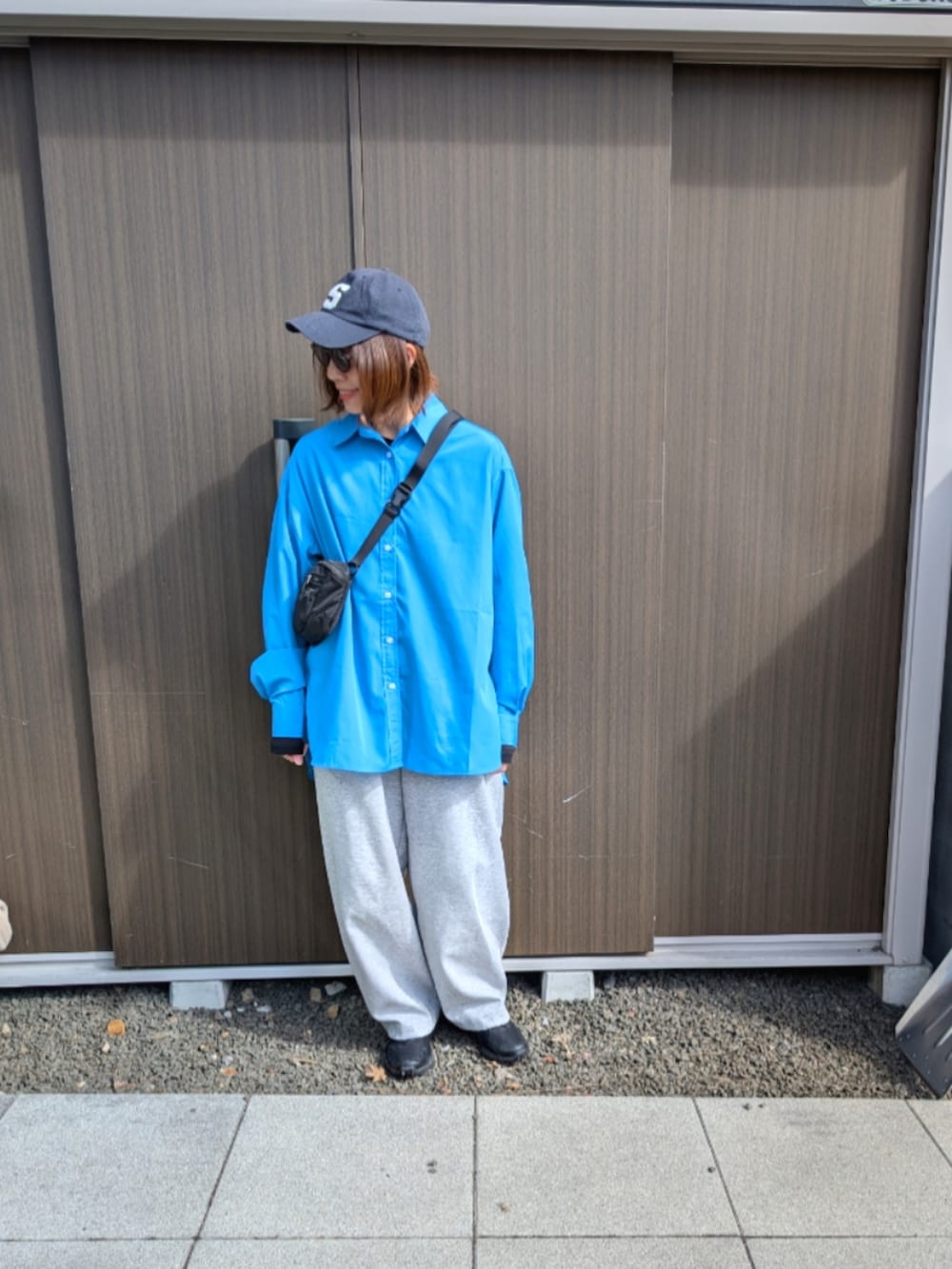 ブルー系のシャツ/ブラウス、グレー系のスウェットパンツ、ブラック系のスニーカーを着用したレディースの春コーディネートの2枚目の写真