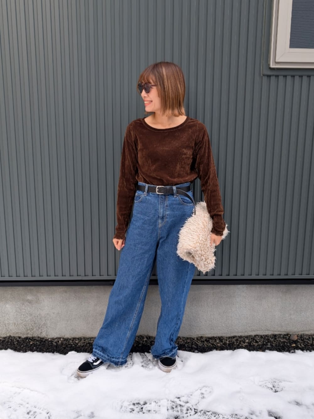 ブラウン系のTシャツ/カットソー、ブルー系のデニムパンツ、グリーン系のミリタリージャケットを着用したレディースの秋コーディネートの2枚目の写真