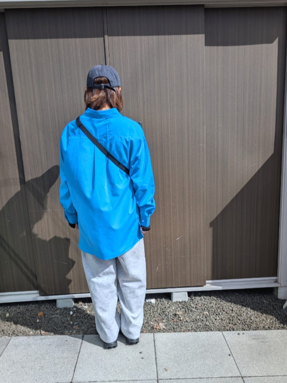 ブルー系のシャツ/ブラウス、グレー系のスウェットパンツ、ブラック系のスニーカーを着用したレディースの春コーディネートの3枚目の写真