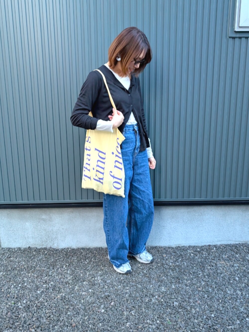 ブラック系のTシャツ/カットソー、ブルー系のデニムパンツ、ホワイト系のスニーカーを着用したレディースの春コーディネートの3枚目の写真