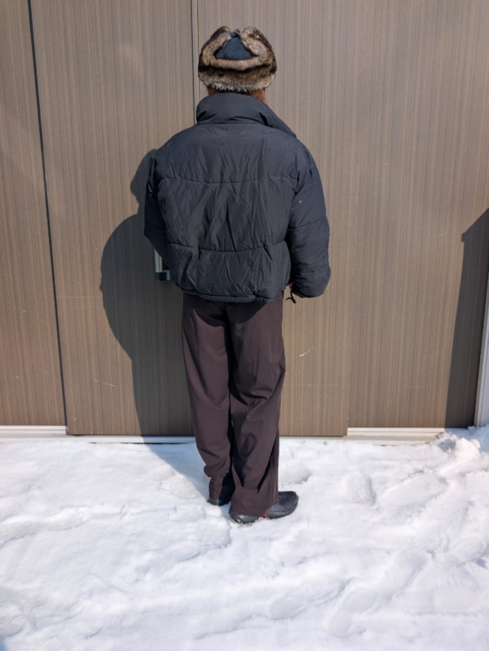 ブラック系のブルゾン、ブラウン系のパンツ、ブラック系のキャップを着用したレディースの冬コーディネートの3枚目の写真