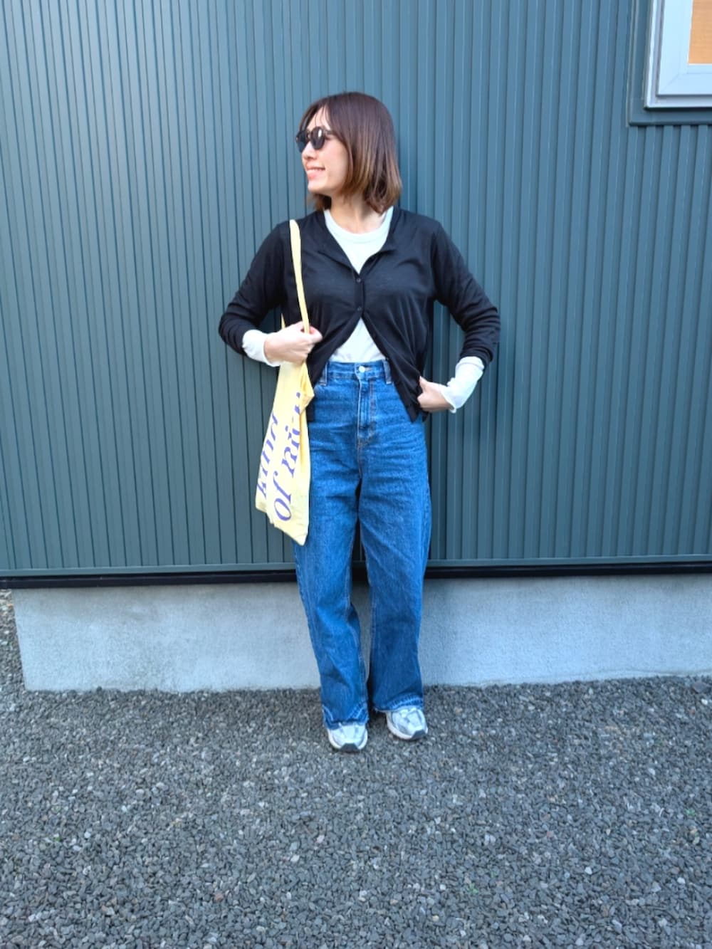 ブラック系のTシャツ/カットソー、ブルー系のデニムパンツ、ホワイト系のスニーカーを着用したレディースの春コーディネートの2枚目の写真