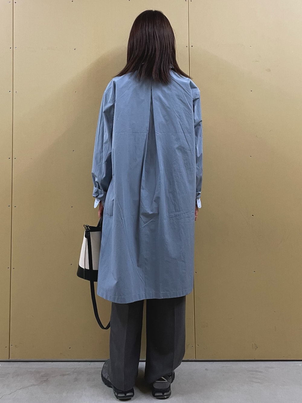 ブルー系のシャツ/ブラウス、ブラック系のショルダーバッグ、ブルー系のステンカラーコートを着用したレディースの春コーディネートの5枚目の写真