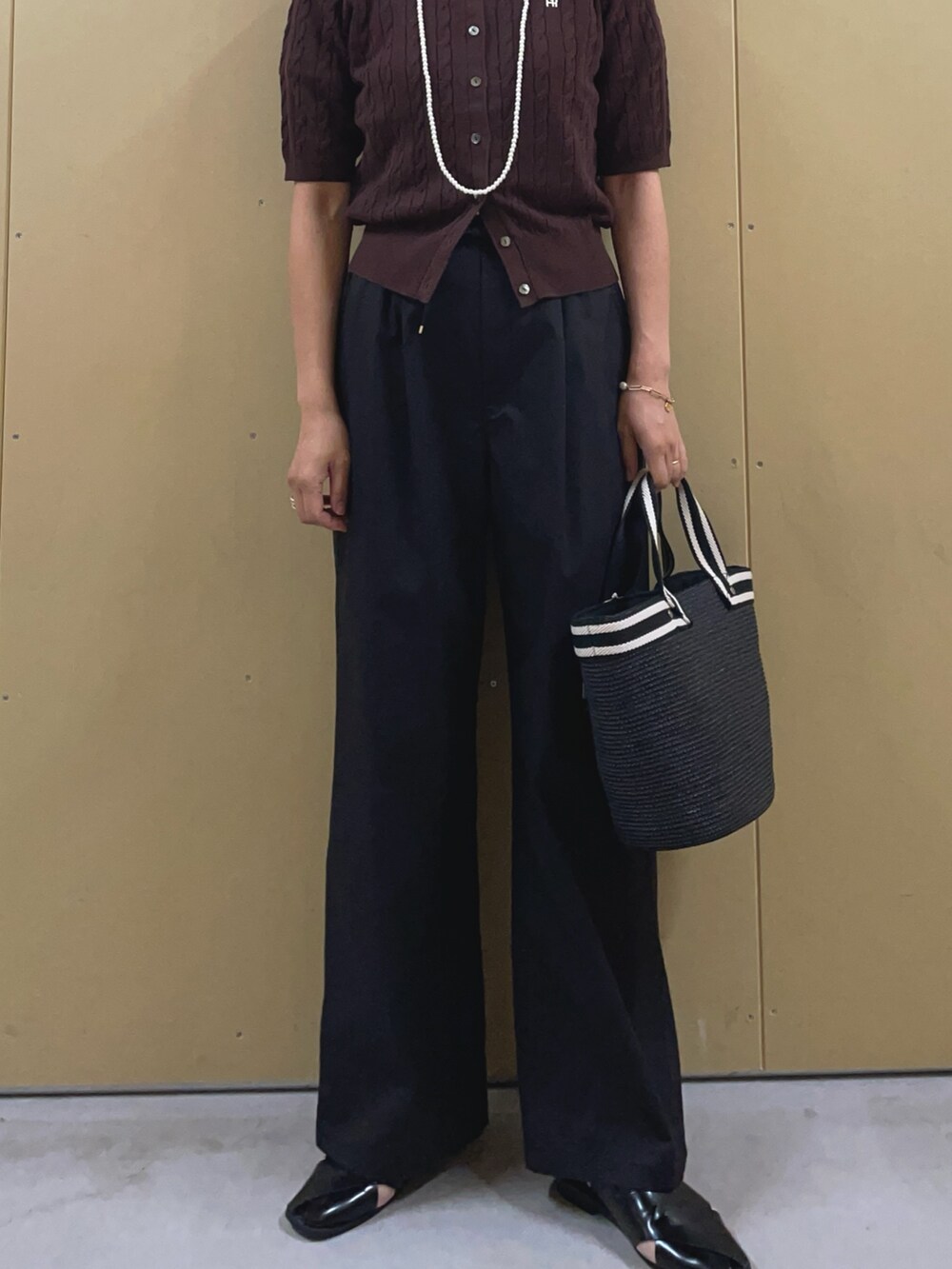 ブラック系のかごバッグ、ブラック系のその他パンツ、ブラウン系のカーディガン/ボレロを着用したレディースの夏コーディネートの6枚目の写真