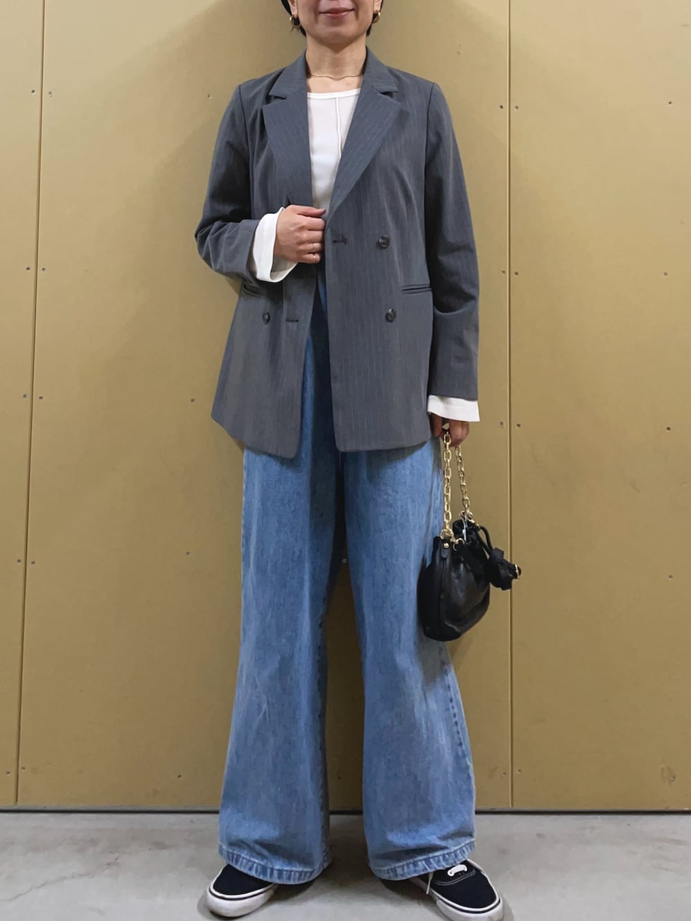 ブルー系のデニムパンツ、ホワイト系のTシャツ/カットソー、ブラック系のショルダーバッグを着用したレディースの冬コーディネートの2枚目の写真