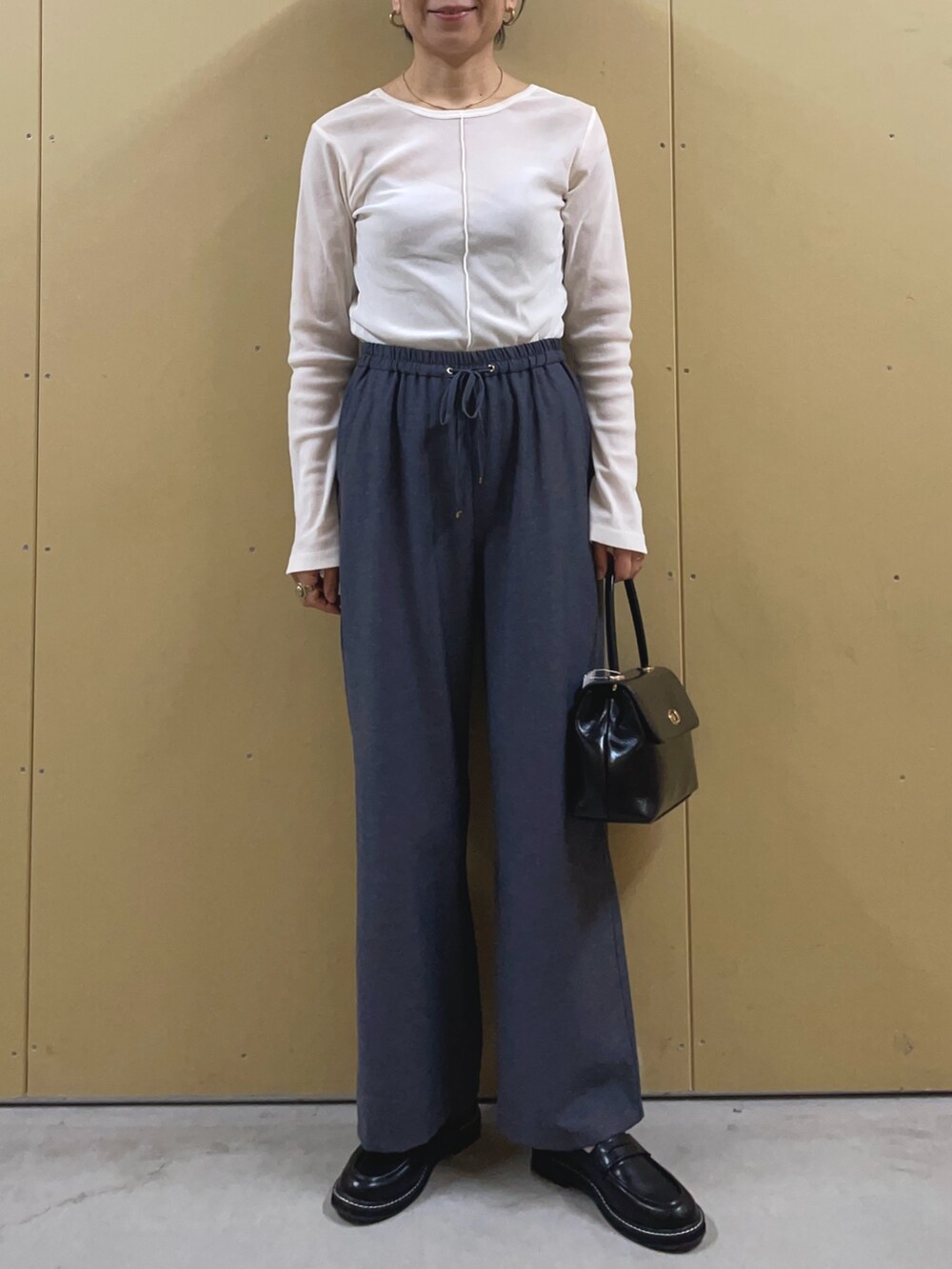 ブラック系のショルダーバッグ、ブルー系のその他パンツ、ブラック系のその他シューズを着用したレディースの春コーディネートの5枚目の写真