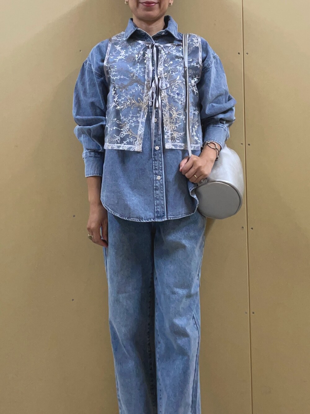 シルバー系のベスト、ブルー系のシャツ/ブラウス、シルバー系のショルダーバッグを着用したレディースの夏コーディネートの5枚目の写真