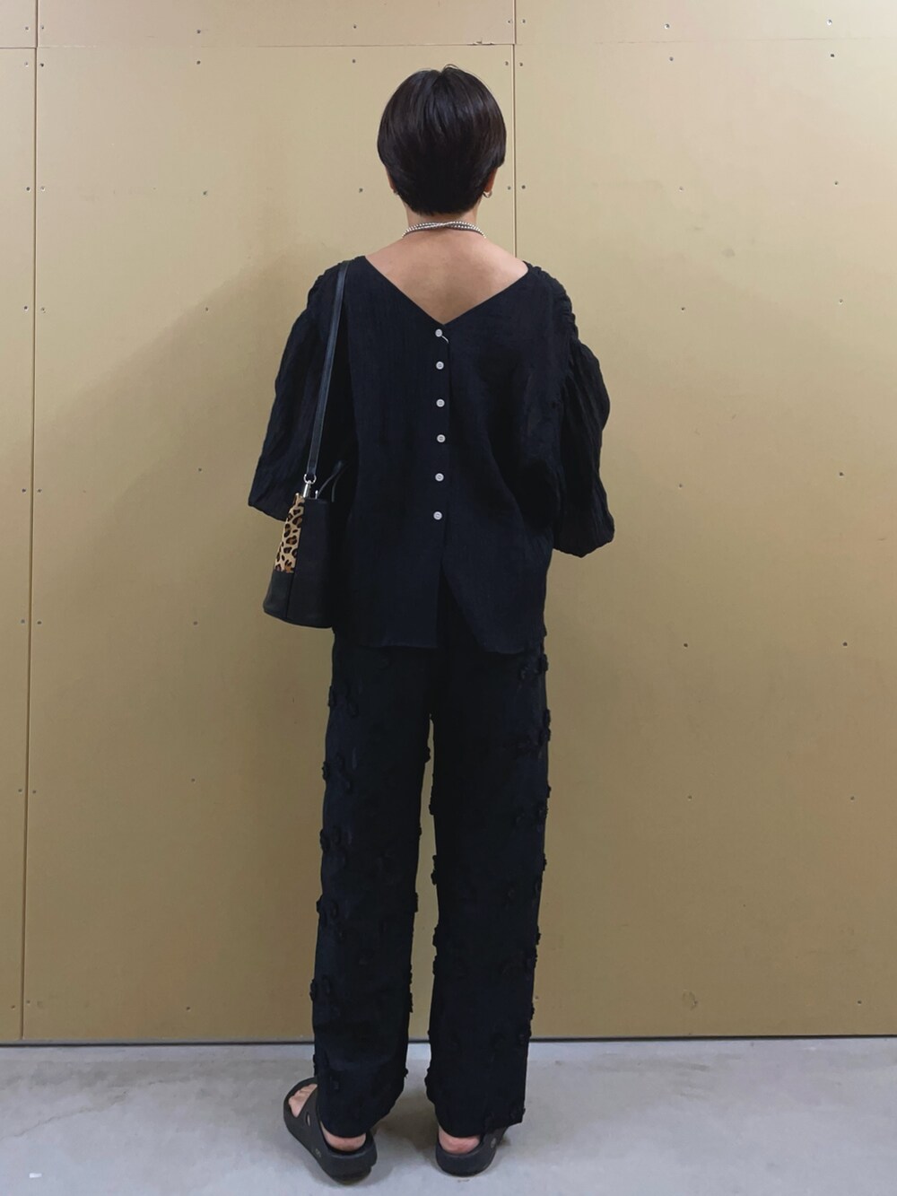ブラック系のサンダル、ブラック系のその他パンツ、ベージュ系のショルダーバッグを着用したレディースの夏コーディネートの4枚目の写真