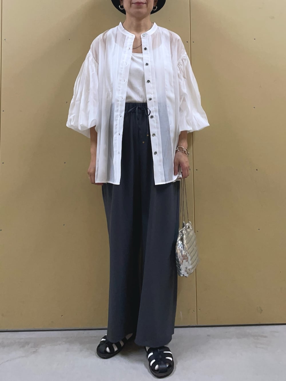 シルバー系のショルダーバッグ、ホワイト系のシャツ/ブラウス、グレー系のその他パンツを着用したレディースの春コーディネートの2枚目の写真