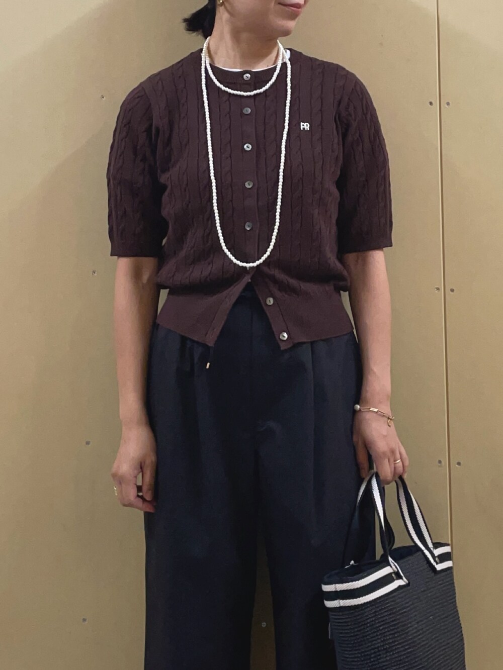 ブラック系のかごバッグ、ブラック系のその他パンツ、ブラウン系のカーディガン/ボレロを着用したレディースの夏コーディネートの5枚目の写真