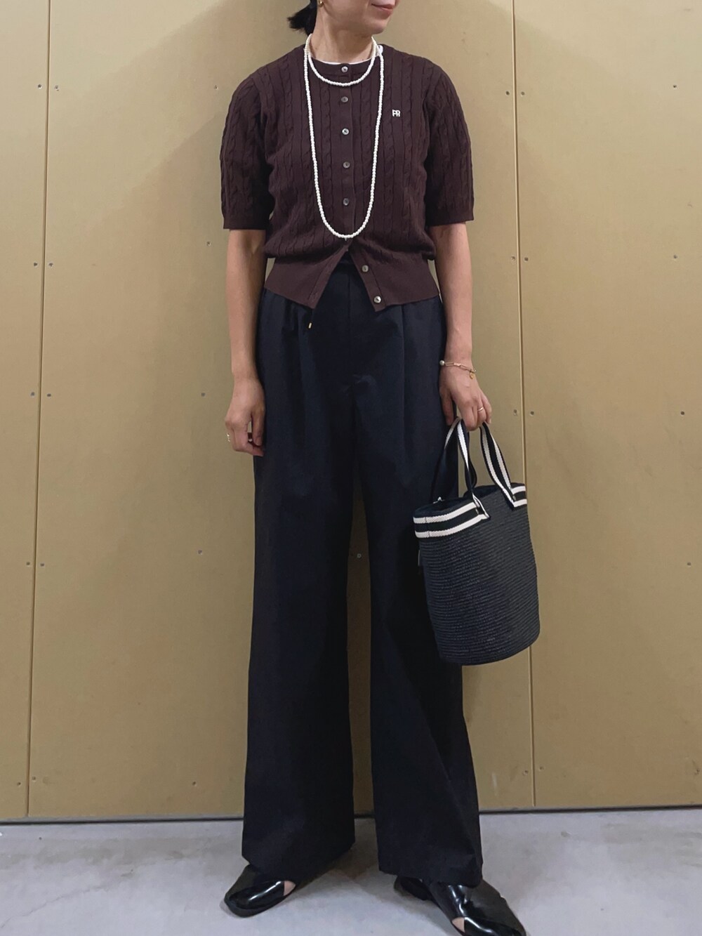 ブラック系のかごバッグ、ブラック系のその他パンツ、ブラウン系のカーディガン/ボレロを着用したレディースの夏コーディネートの2枚目の写真
