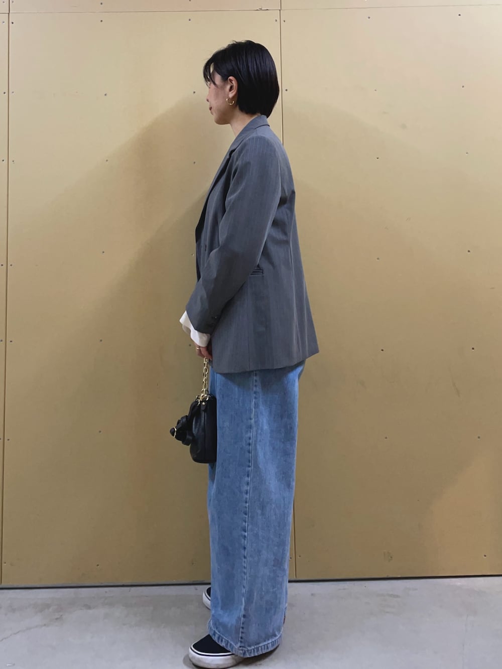 ブルー系のデニムパンツ、ホワイト系のTシャツ/カットソー、ブラック系のショルダーバッグを着用したレディースの冬コーディネートの3枚目の写真