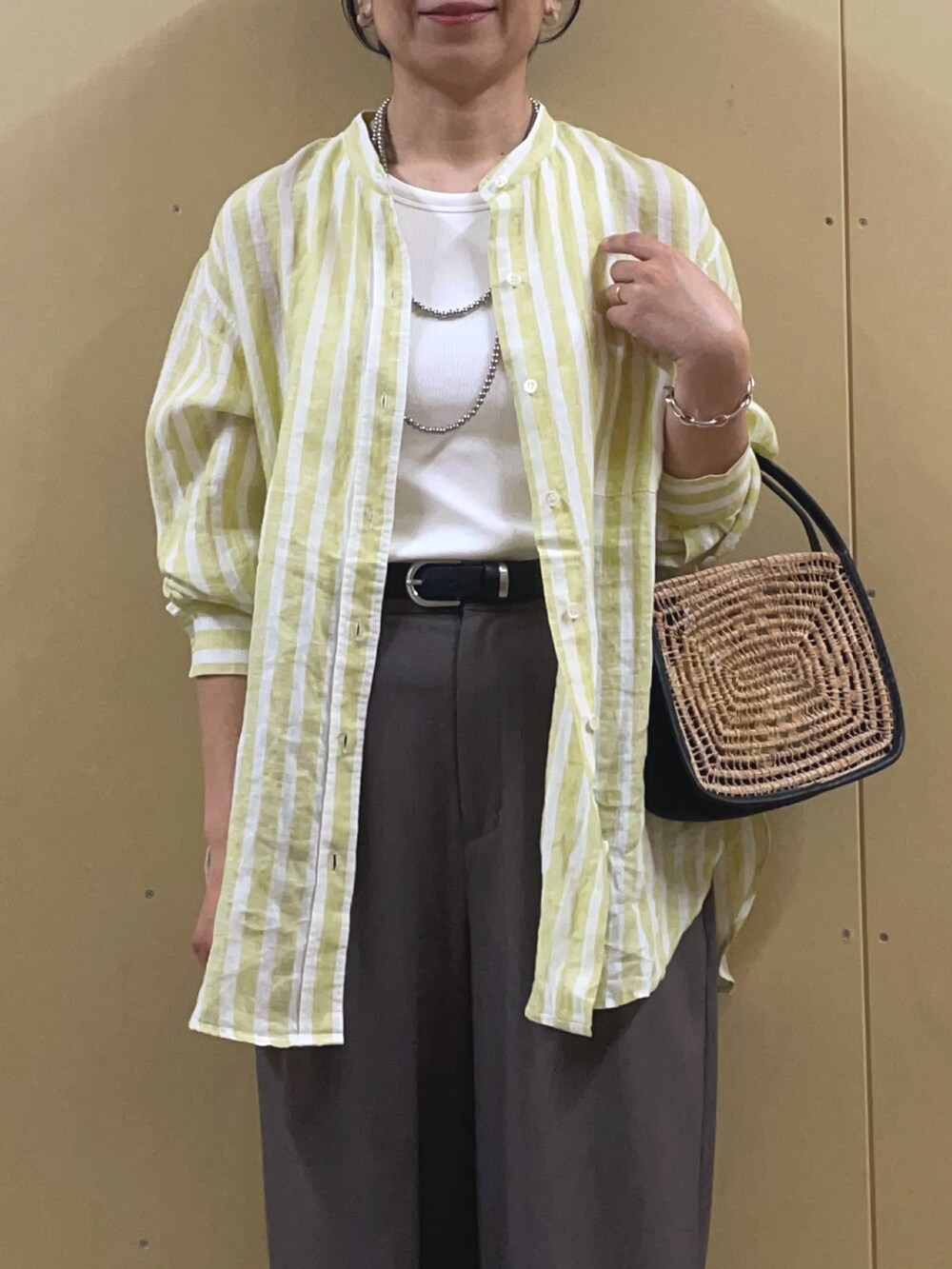 イエロー系のシャツ/ブラウス、ブラック系のサンダル、シルバー系のネックレスを着用したレディースの春コーディネートの5枚目の写真
