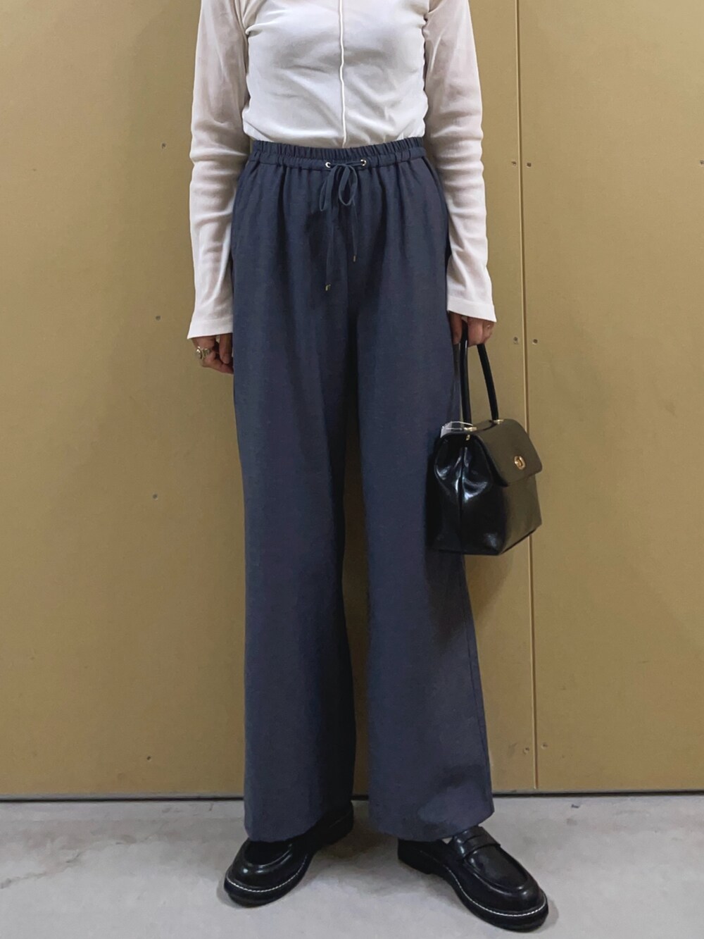 ブラック系のショルダーバッグ、ブルー系のその他パンツ、ブラック系のその他シューズを着用したレディースの春コーディネートの2枚目の写真