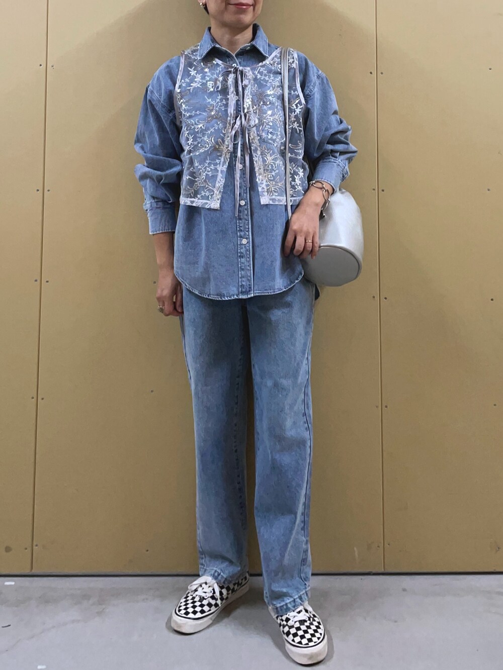 シルバー系のベスト、ブルー系のシャツ/ブラウス、シルバー系のショルダーバッグを着用したレディースの夏コーディネートの6枚目の写真