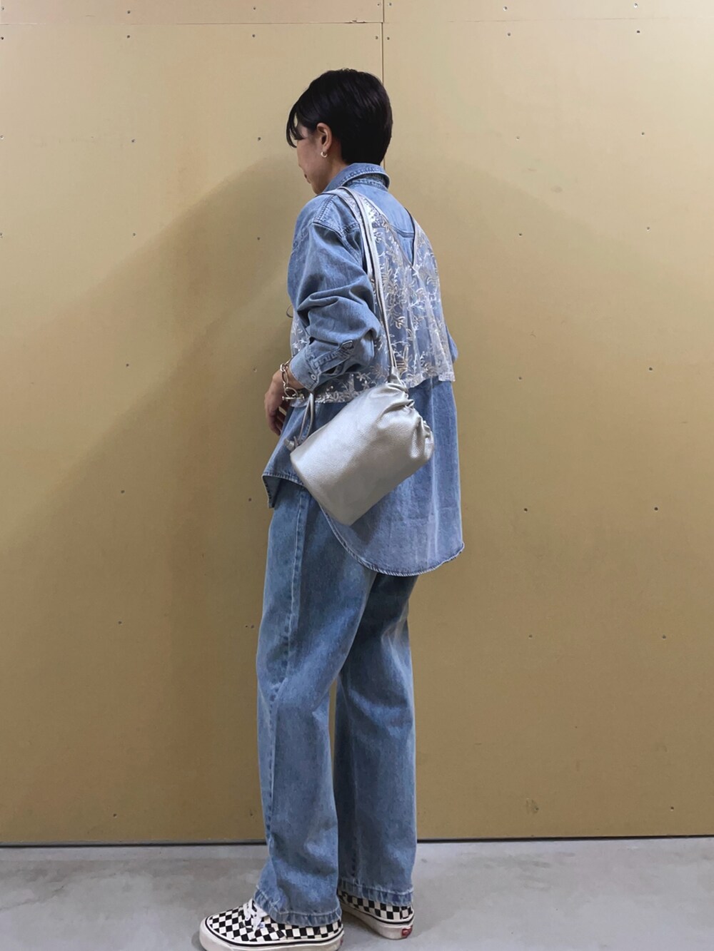 シルバー系のベスト、ブルー系のシャツ/ブラウス、シルバー系のショルダーバッグを着用したレディースの夏コーディネートの3枚目の写真