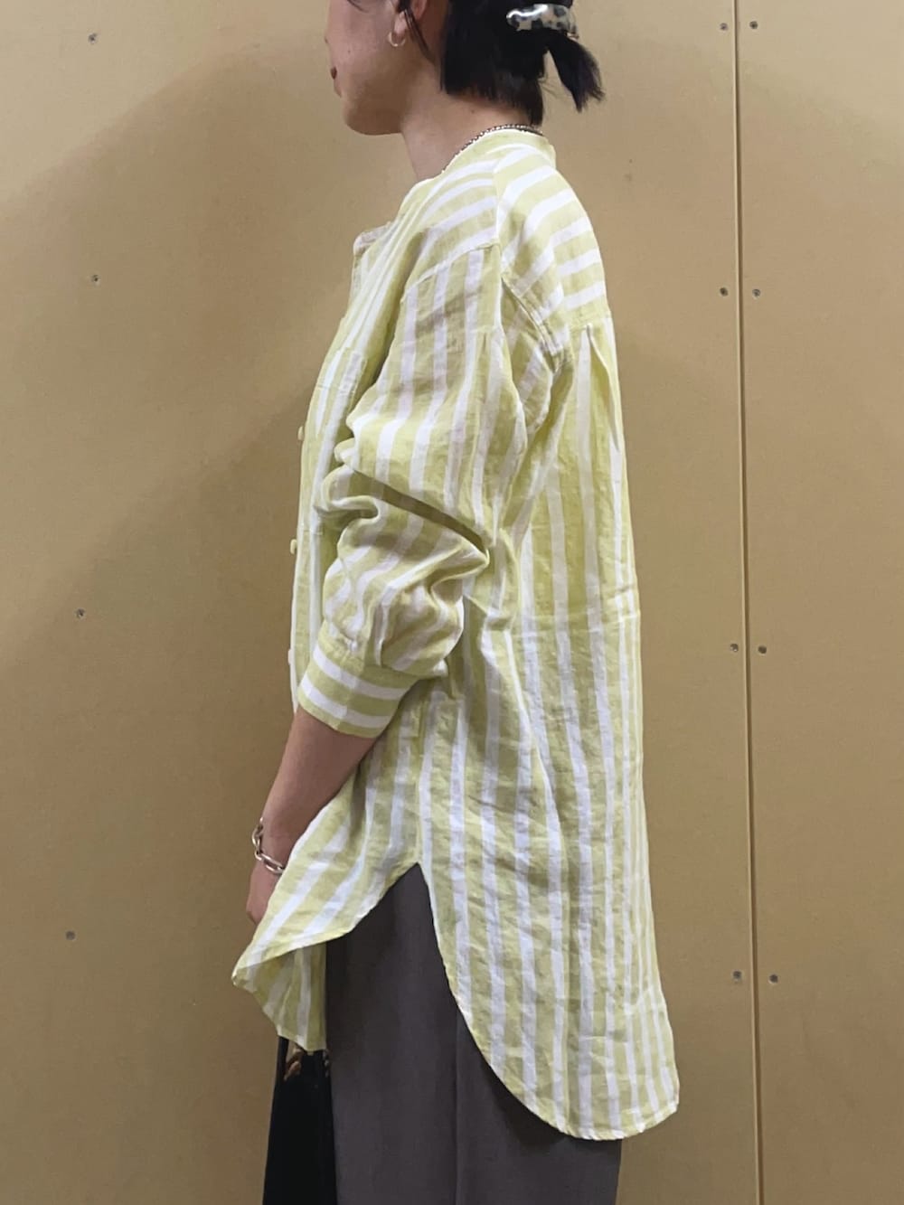 イエロー系のシャツ/ブラウス、ブラック系のサンダル、シルバー系のネックレスを着用したレディースの春コーディネートの6枚目の写真