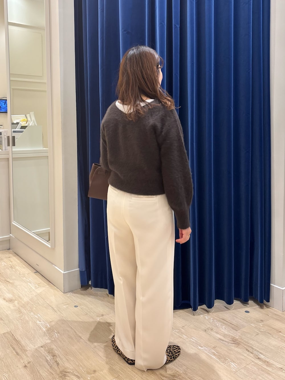 ブラウン系のニット/セーター、ブラウン系のトートバッグ、ホワイト系のその他パンツを着用したレディースの秋コーディネートの6枚目の写真