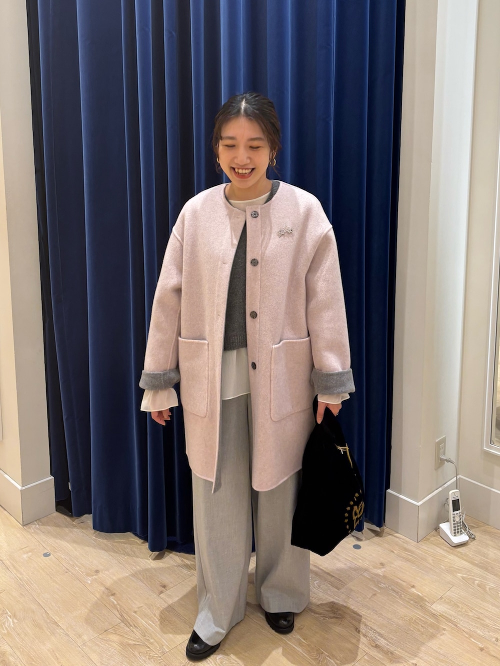 グレー系のノーカラーコート、グレー系のニット/セーター、グレー系のその他パンツを着用したレディースの秋コーディネートの3枚目の写真