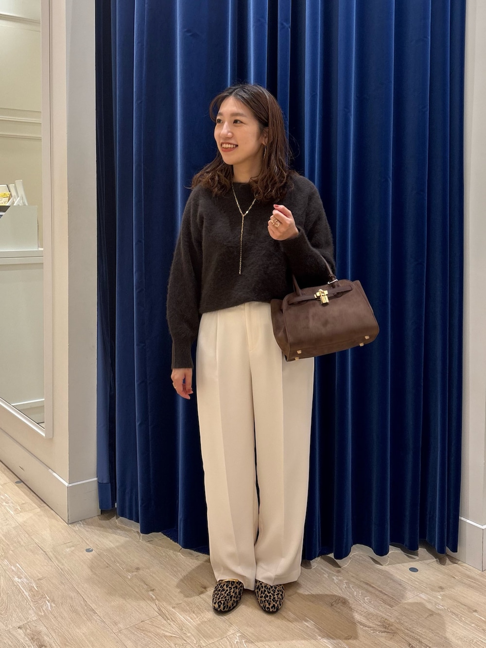 ブラウン系のニット/セーター、ブラウン系のトートバッグ、ホワイト系のその他パンツを着用したレディースの秋コーディネートの5枚目の写真