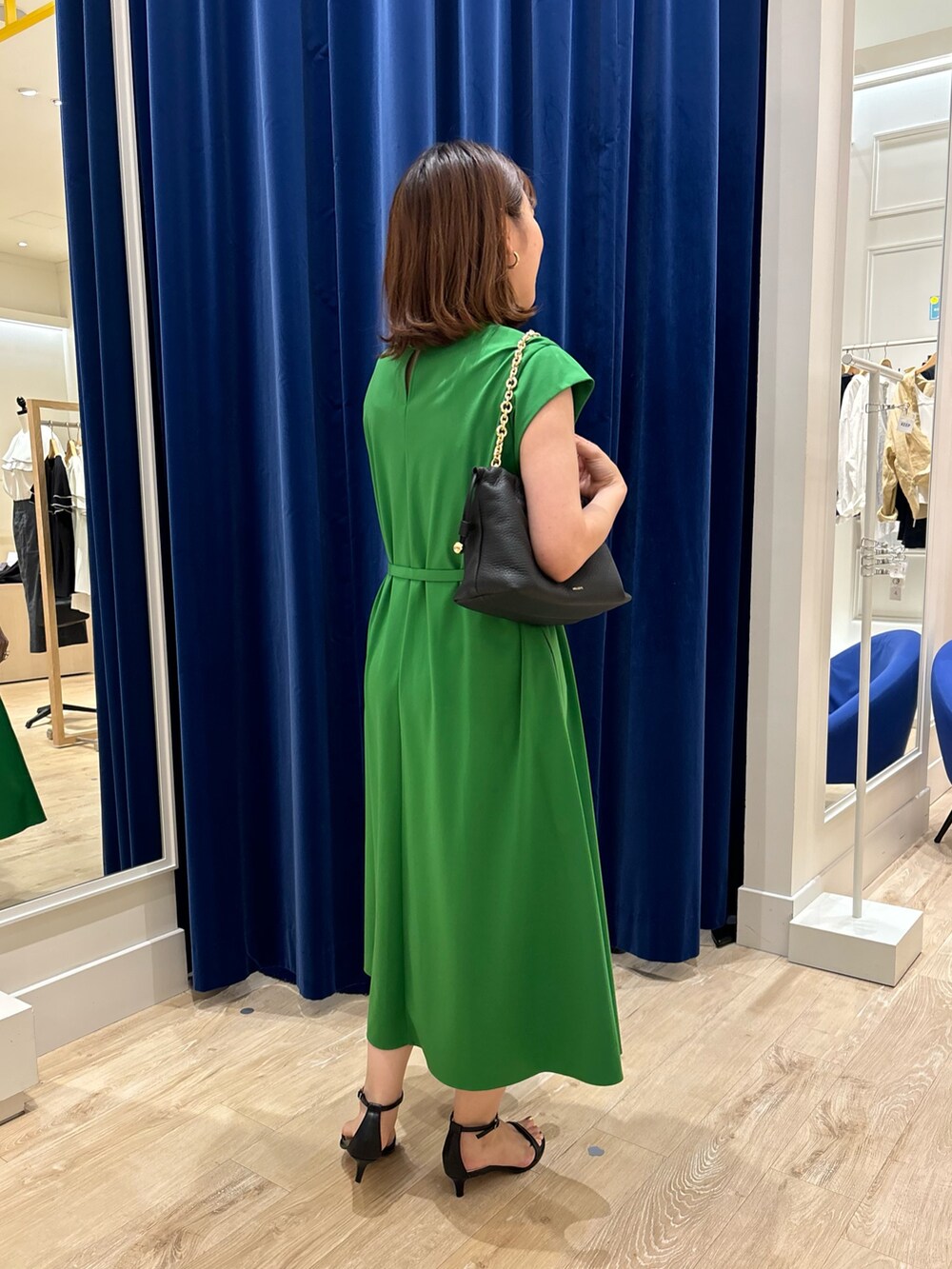 グリーン系のワンピース、ブラック系のショルダーバッグ、ブラック系のサンダルを着用したレディースの夏コーディネートの3枚目の写真