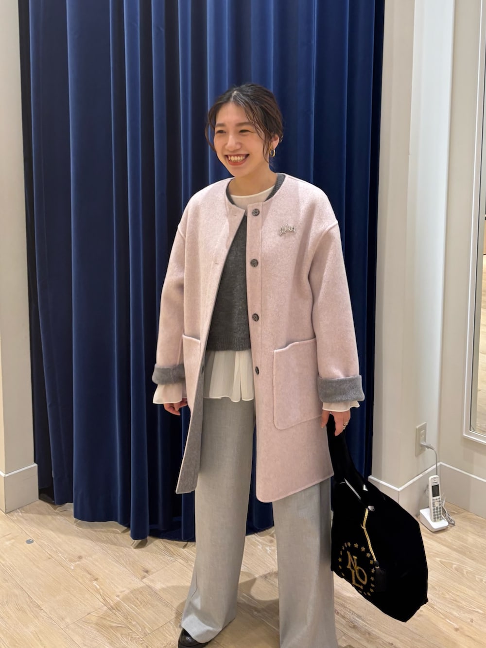 グレー系のノーカラーコート、グレー系のニット/セーター、グレー系のその他パンツを着用したレディースの秋コーディネートの2枚目の写真