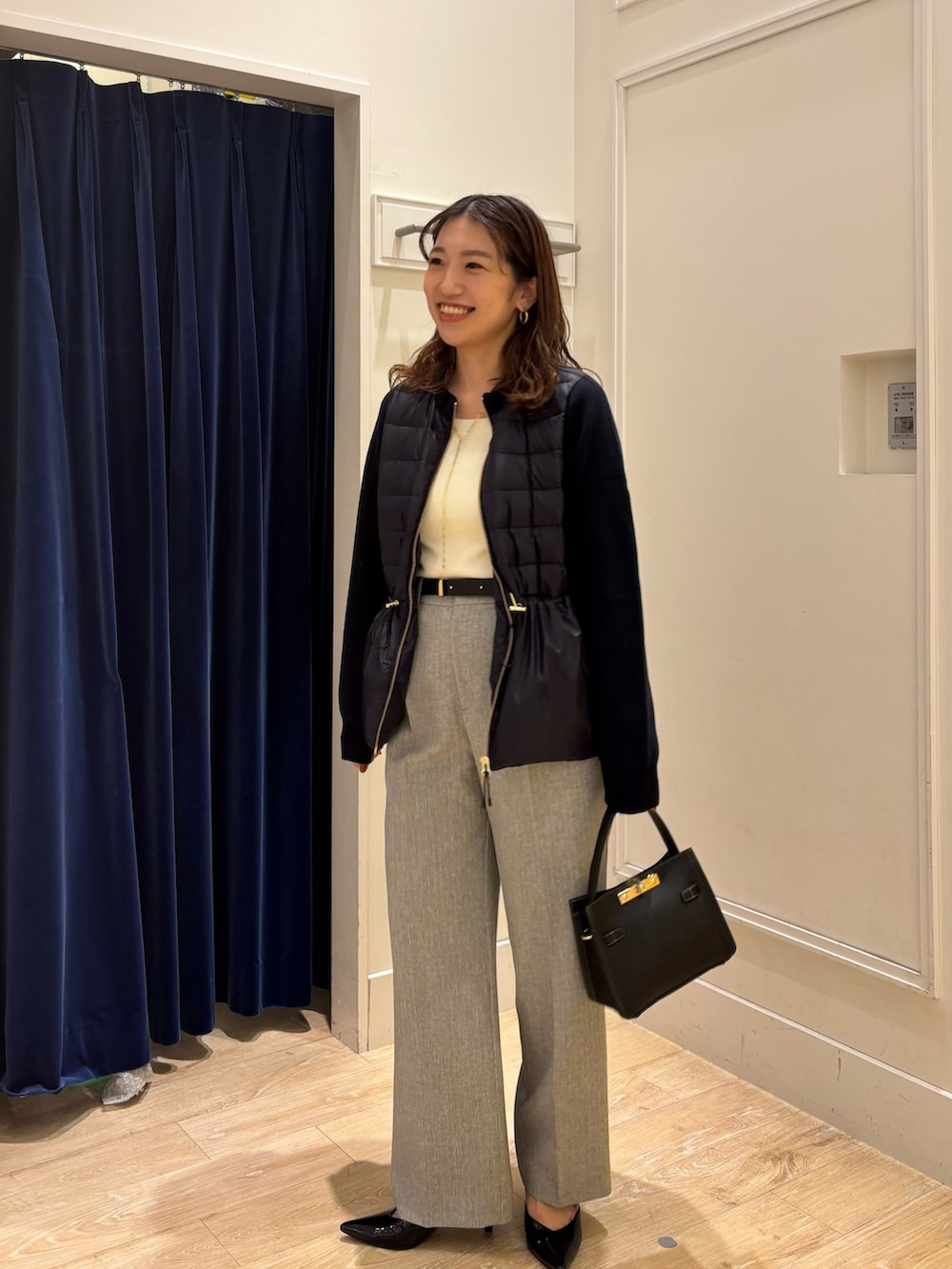 グレー系のその他パンツ、ブラック系のショルダーバッグ、ホワイト系のニット/セーターを着用したレディースの秋コーディネートの2枚目の写真