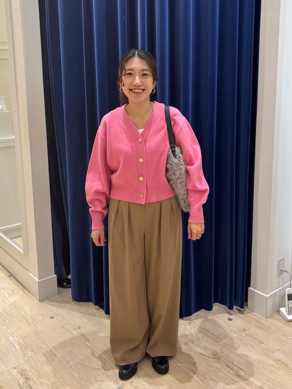 イエロー系のその他パンツ、ピンク系のカーディガン/ボレロ、ベージュ系のショルダーバッグを着用したレディースの秋コーディネートの2枚目の写真