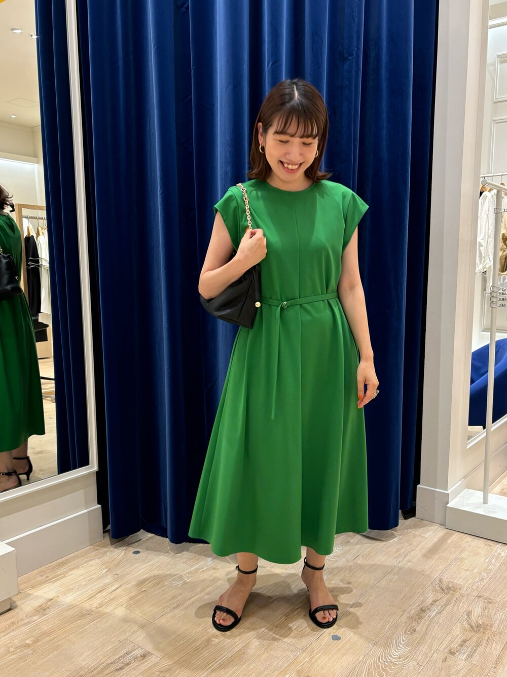 グリーン系のワンピース、ブラック系のショルダーバッグ、ブラック系のサンダルを着用したレディースの夏コーディネートの5枚目の写真