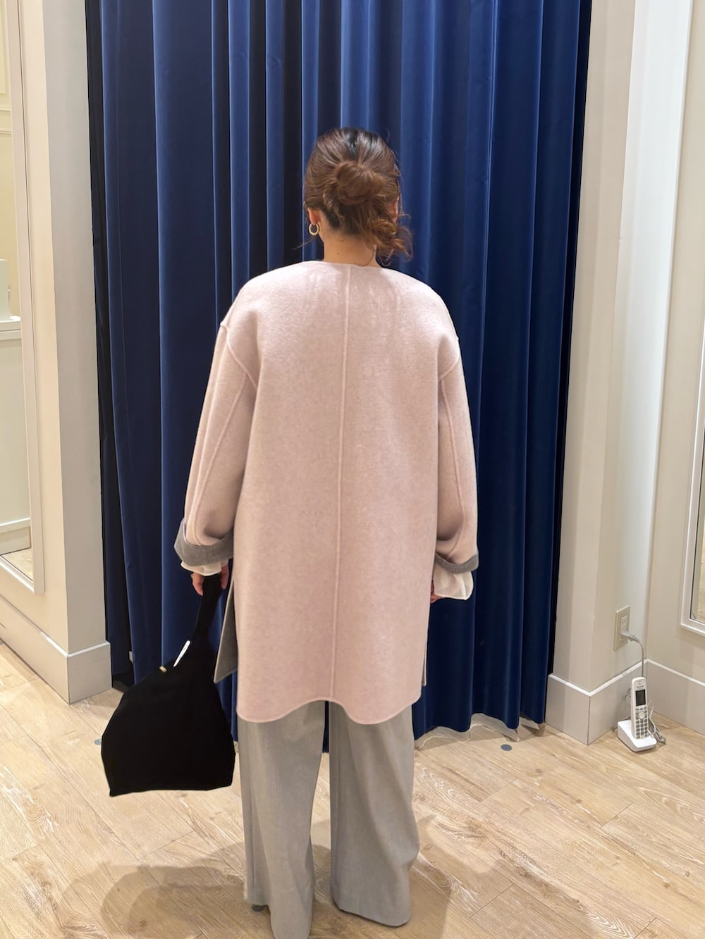 グレー系のノーカラーコート、グレー系のニット/セーター、グレー系のその他パンツを着用したレディースの秋コーディネートの6枚目の写真