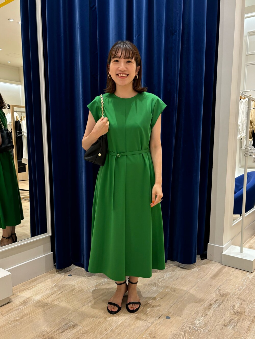 グリーン系のワンピース、ブラック系のショルダーバッグ、ブラック系のサンダルを着用したレディースの夏コーディネートの4枚目の写真