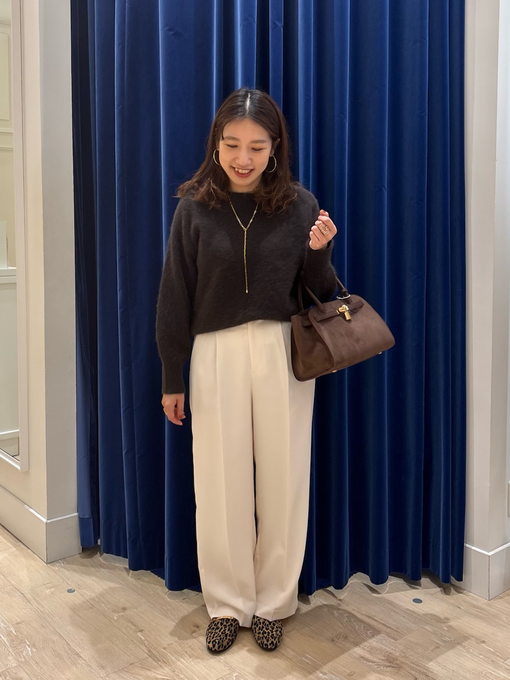 ブラウン系のニット/セーター、ブラウン系のトートバッグ、ホワイト系のその他パンツを着用したレディースの秋コーディネートの4枚目の写真