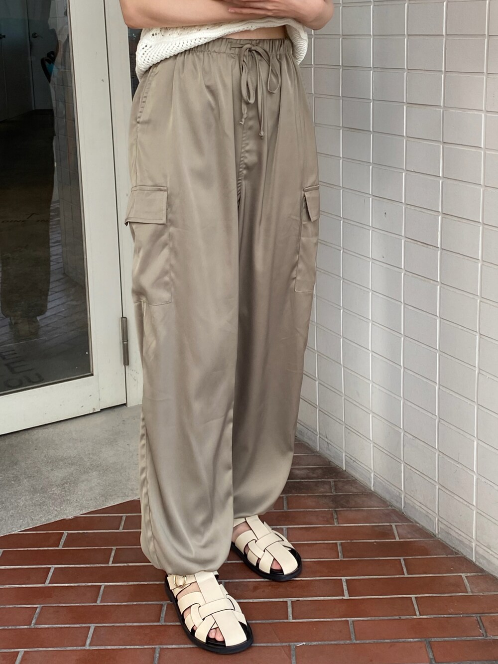 グリーン系のカーゴパンツ、ホワイト系のサンダルを着用したレディースの夏コーディネートの2枚目の写真