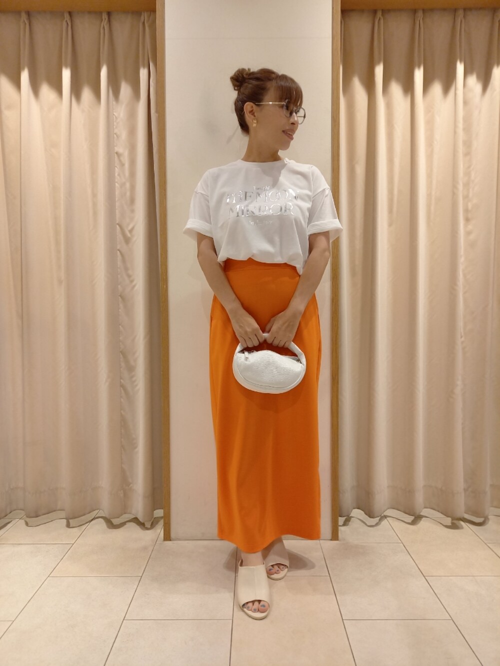 ホワイト系のTシャツ/カットソー、オレンジ系のスカートを着用したレディースの夏コーディネートの3枚目の写真