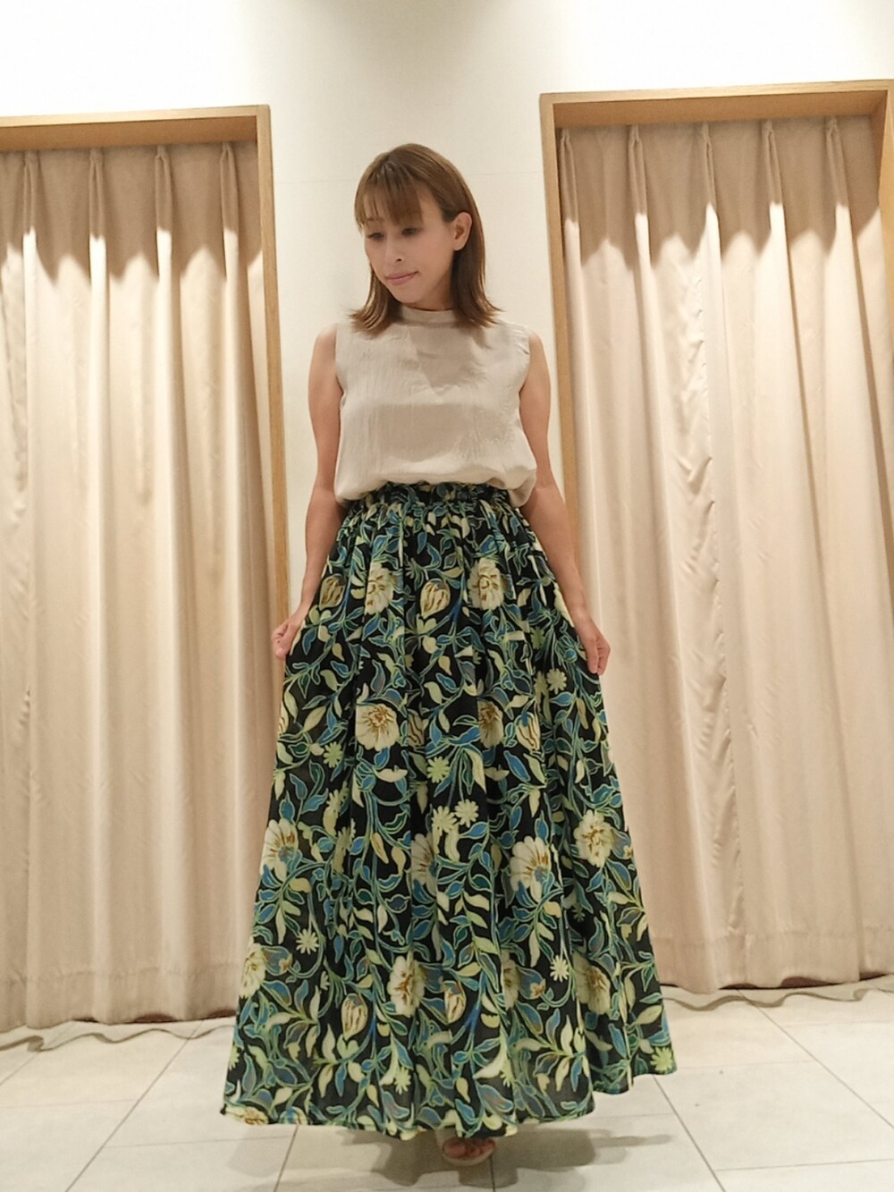 ベージュ系のシャツ/ブラウス、ブラック系のスカートを着用したレディースの夏コーディネートの2枚目の写真