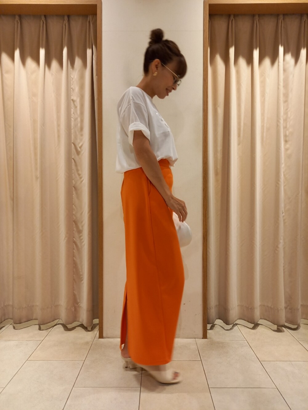 ホワイト系のTシャツ/カットソー、オレンジ系のスカートを着用したレディースの夏コーディネートの4枚目の写真