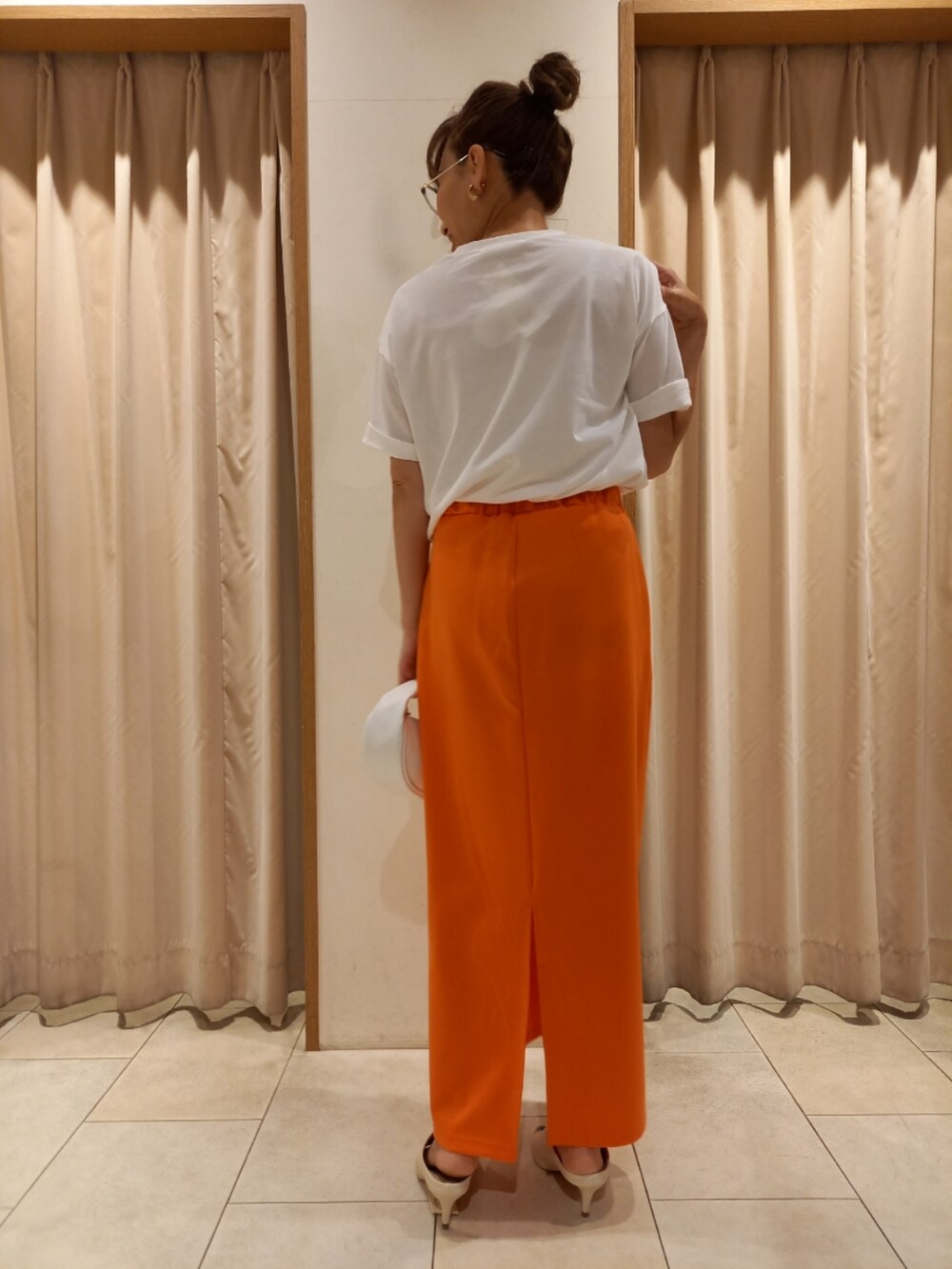 ホワイト系のTシャツ/カットソー、オレンジ系のスカートを着用したレディースの夏コーディネートの5枚目の写真